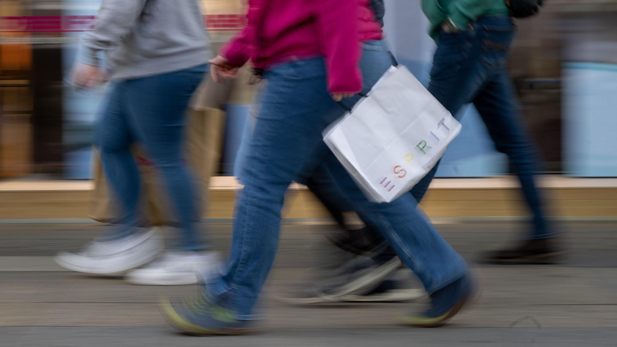 Menschen mit vollen Einkaufstaschen gehen an den Geschäften in der Tauentzienstraße vorbei.