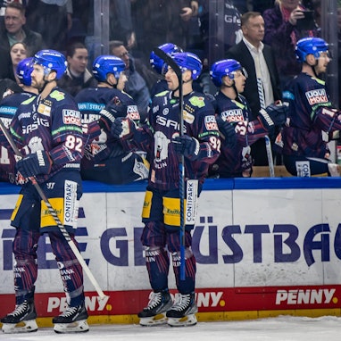 Berlins Alexandre Grenier (l) und Marcel Noebels klatschen mit Teamkollegen ab.
