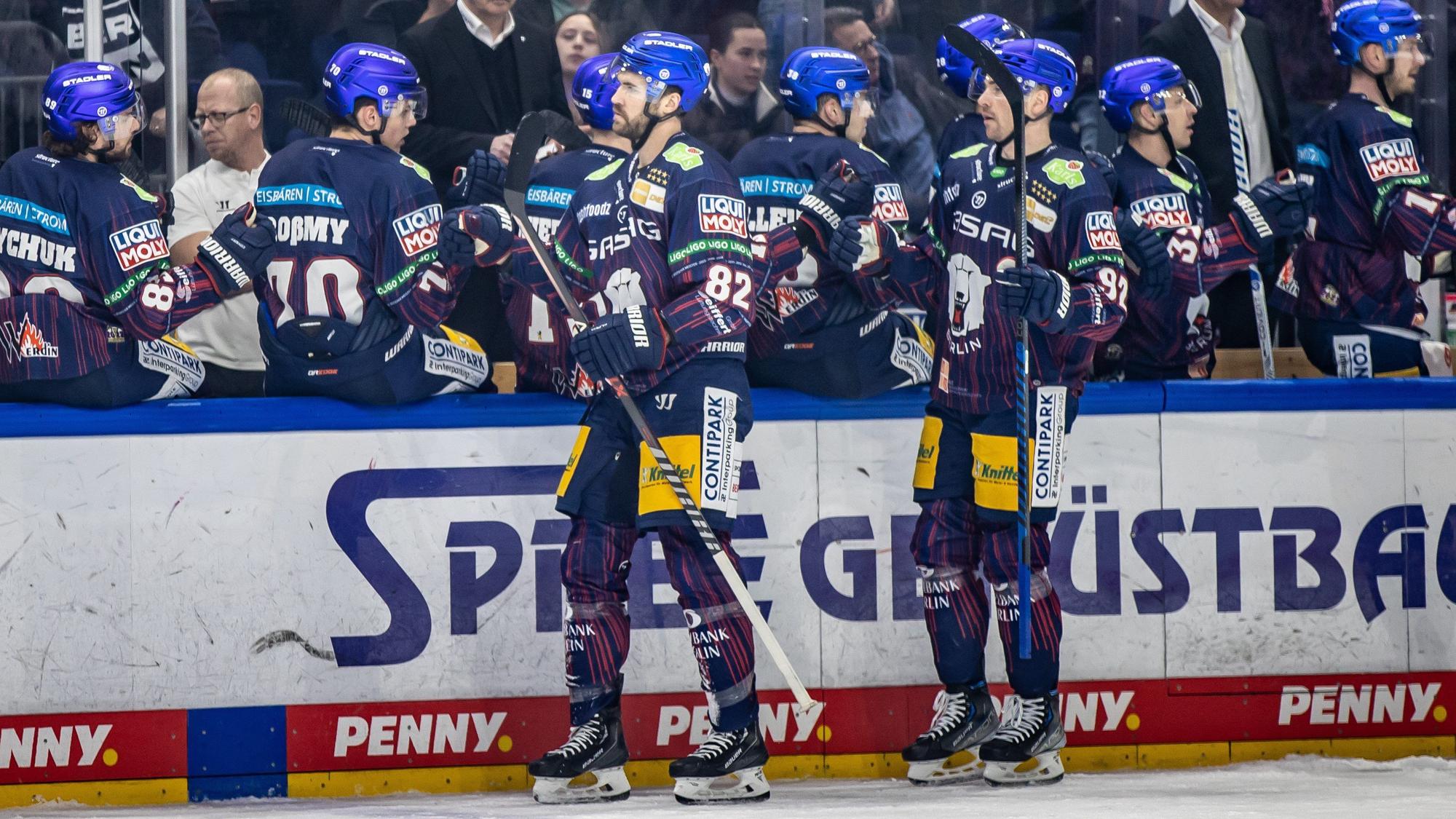 Berlins Alexandre Grenier (l) und Marcel Noebels klatschen mit Teamkollegen ab.