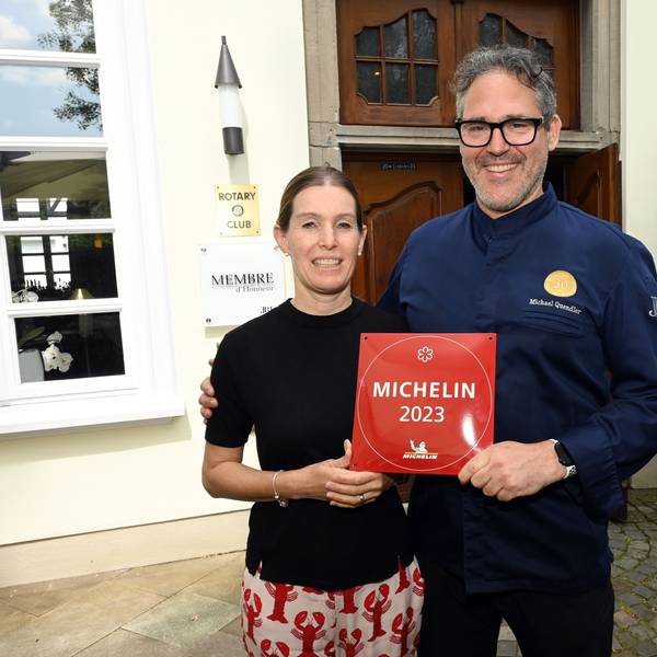 Ein Ehepaar steht vor seinem Restaurant, mit der Auszeichnung „Michelin 2023“ in den Händen
