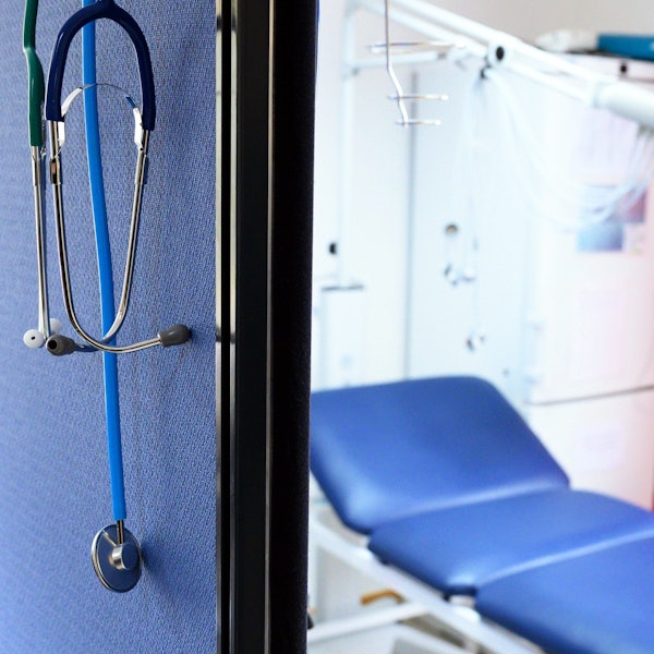 Stethoskope hängen im Behandlungszimmer einer Hausarztpraxis über einer Trennwand.