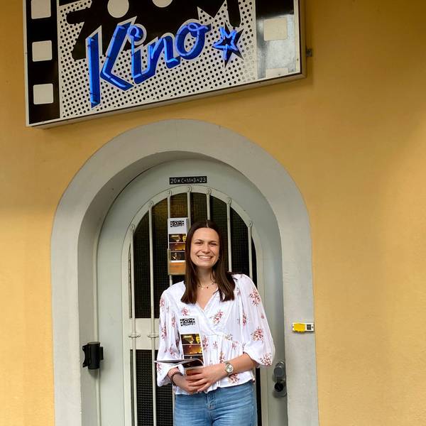 Julia Liebig steht vor dem Eingang des Brühler Zoom-Kinos. Sie hält ein Programm in den Händen.
