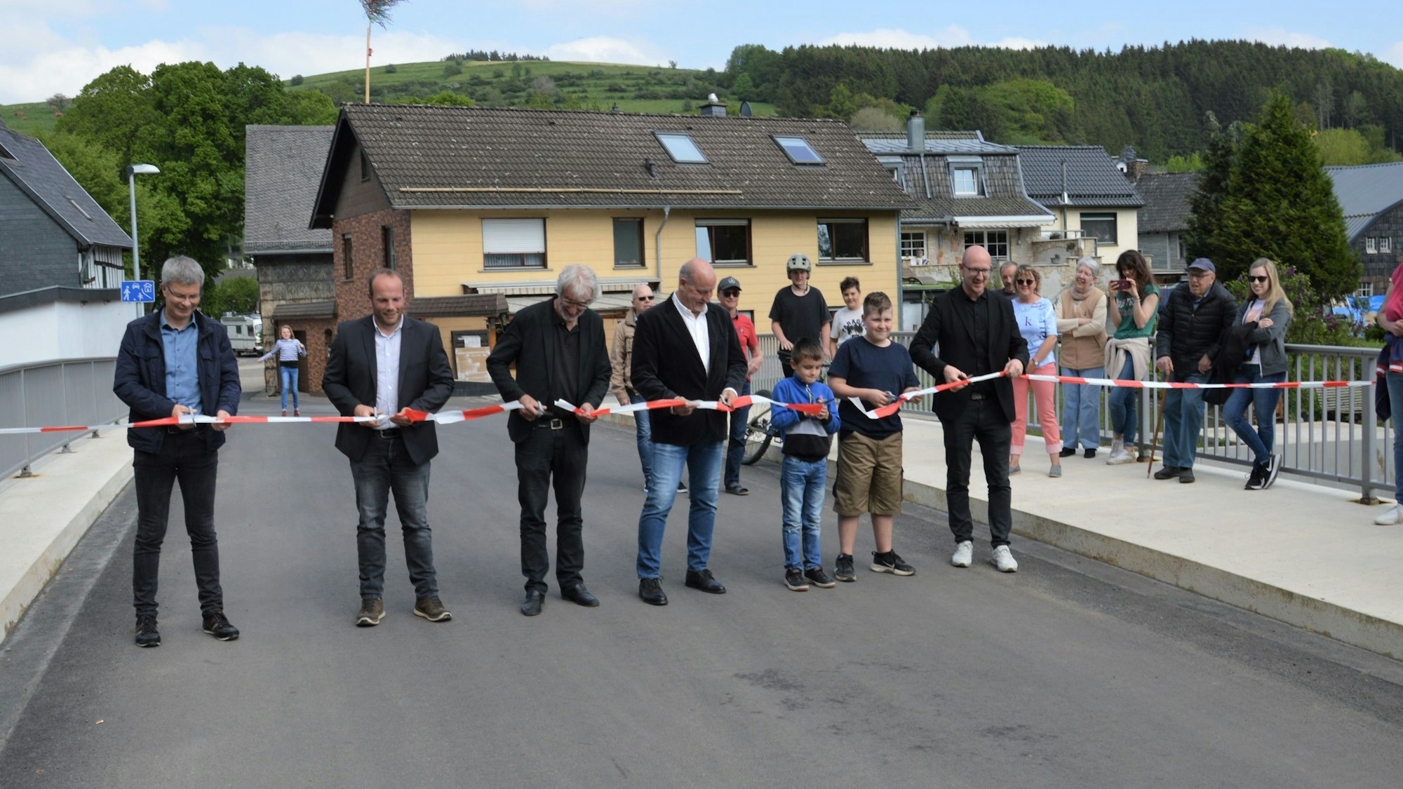 Beim Durchschneiden des Bandes hatte Bürgermeister Ingo Pfennings (r.) zahlreiche große und kleine Helfer.