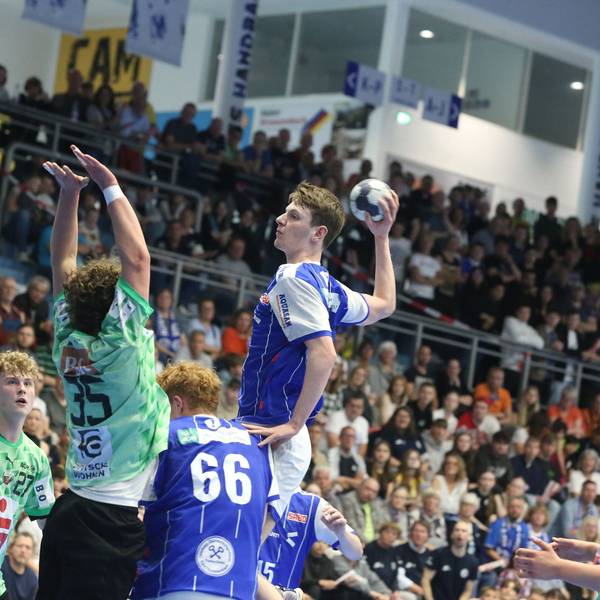 Ein Gummersbacher U17-Handballer hebt vor der gegnerischen Abwehr zum Sprungwurf ab.