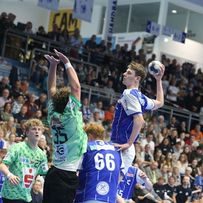 Ein Gummersbacher U17-Handballer hebt vor der gegnerischen Abwehr zum Sprungwurf ab.