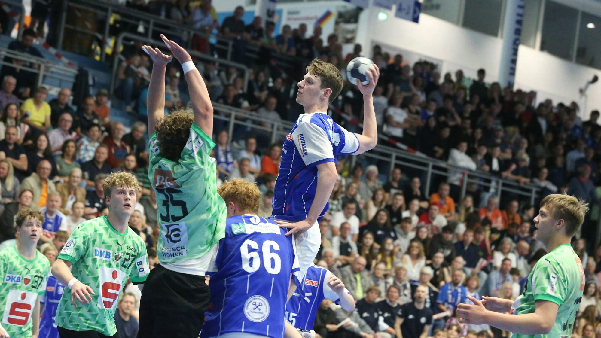 Ein Gummersbacher U17-Handballer hebt vor der gegnerischen Abwehr zum Sprungwurf ab.