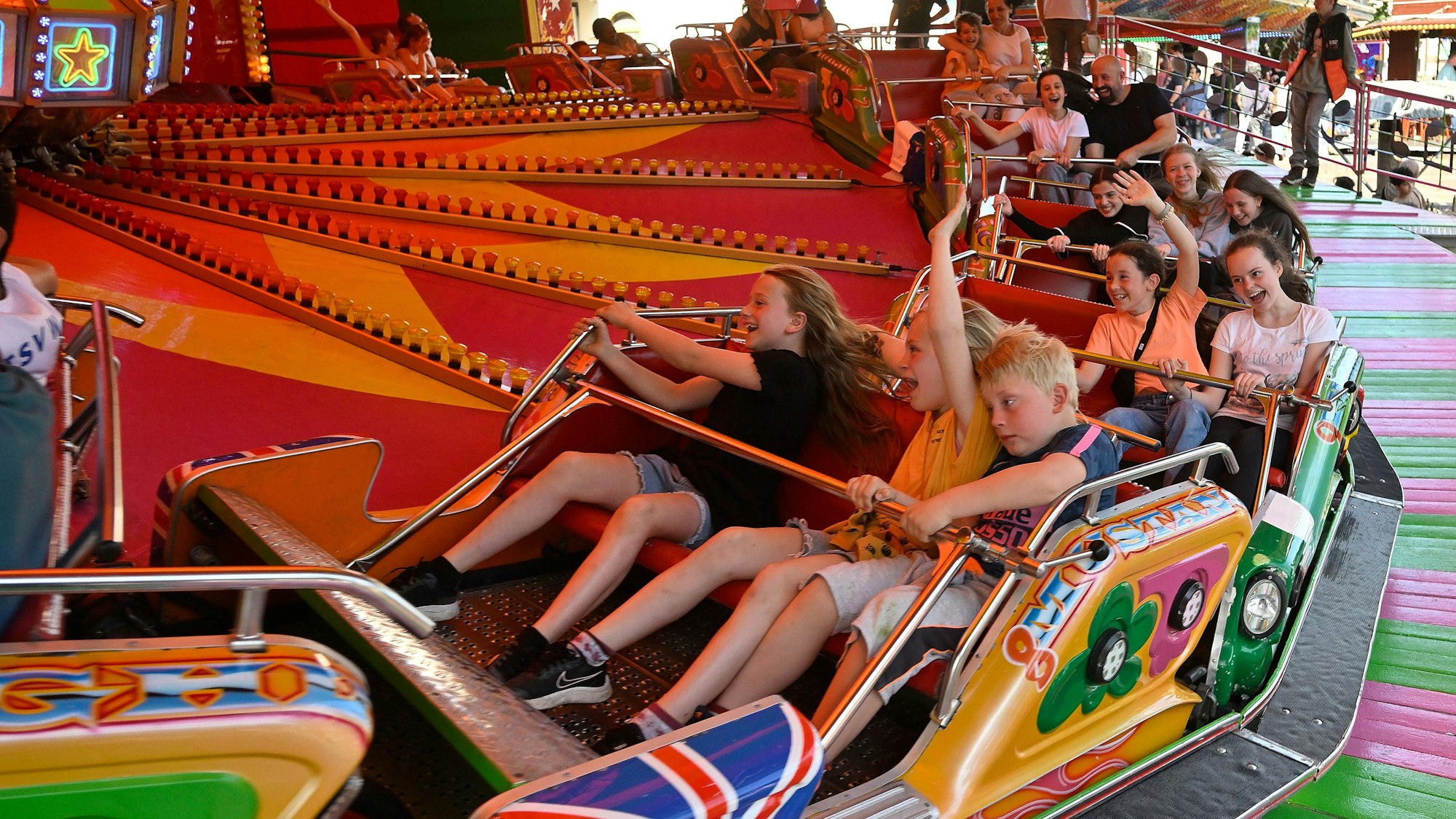 Kirmesbesucher erfreuen sich an einer rauschenden Fahrt in einer Raupe.
