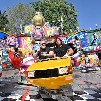 Im Kirmesfahrgeschäft Break Dancer vergnügen sich Menschen bei Sonnenschein und strahlend blauem Himmel.