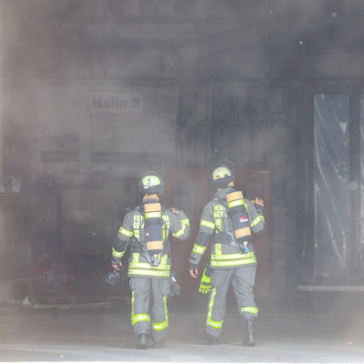 Kräfte der Feuerwehr sind nach einer Explosion in einer Industriehalle im Einsatz.