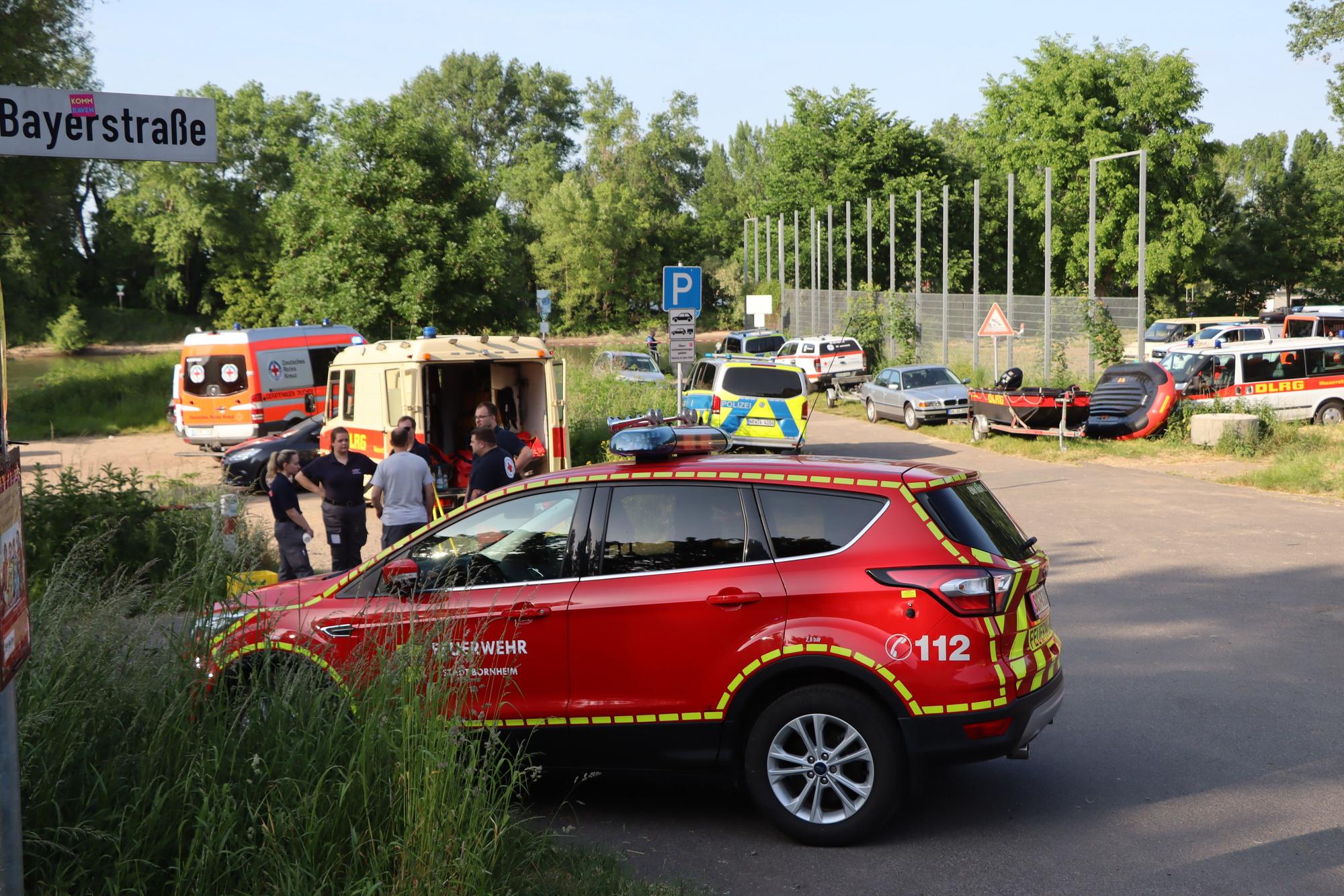 Einsatzfahrzeuge stehen am Herseler Rheinufer. Ein Kind und sein Vater wurde dort von der Strömung mitgerissen.