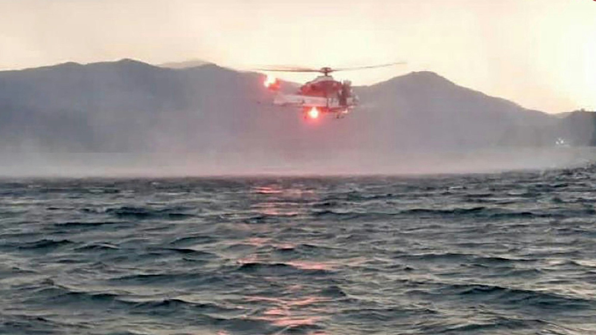 Dieses von der italienischen Feuerwehr veröffentlichten Bild zeigt einen Hubschrauber bei der Suche nach Vermissten, nachdem ein Touristen-Boot in einem Sturm auf dem italienischen Lago Maggiore gekentert ist.