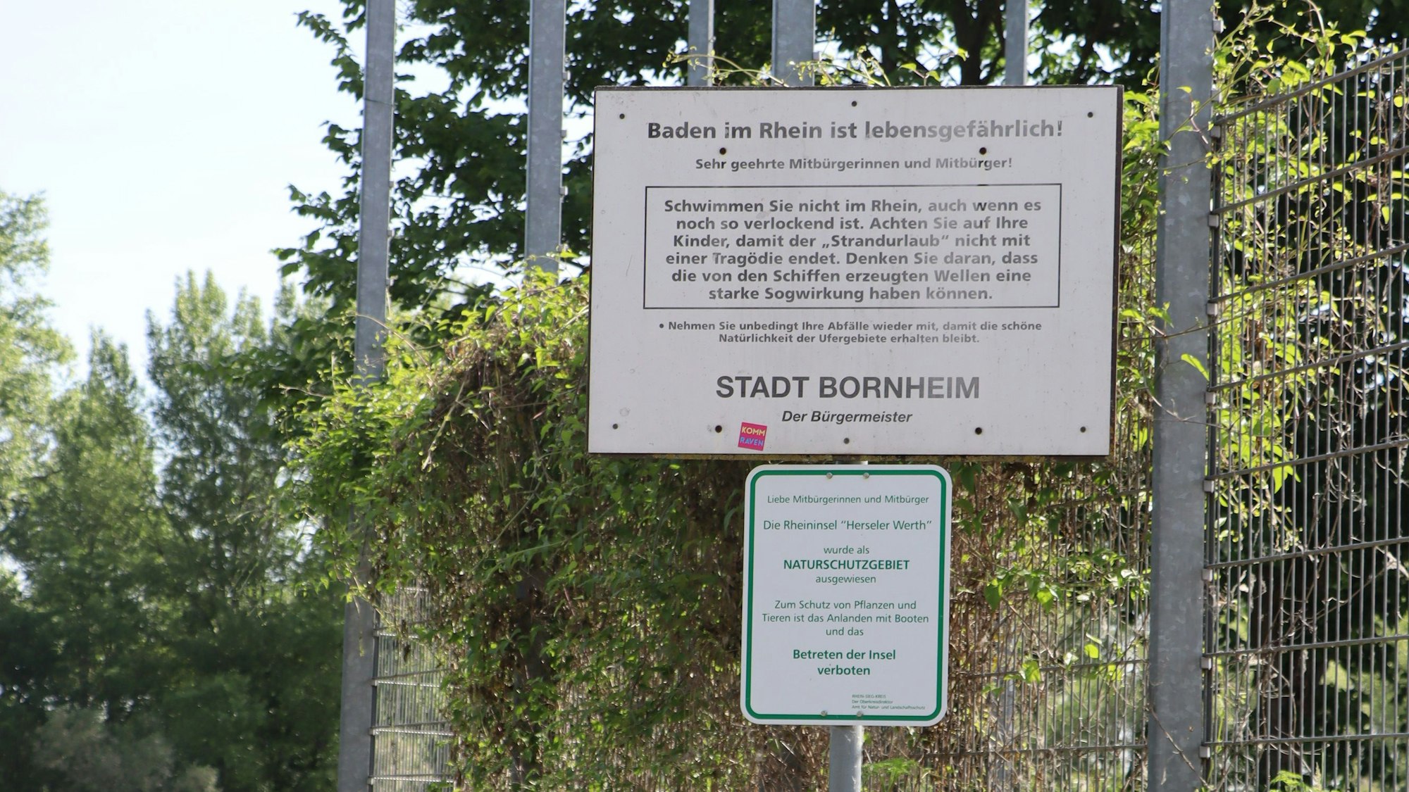Ein Schild weist auf die Gefahren des Rheins hin. An sonnigen Tagen und an den Wochenenden ist am Rheinufer immer viel Betrieb. An einige Stellen sind auch die Rückstände von Lagerfeuer deutlich zu sehen.