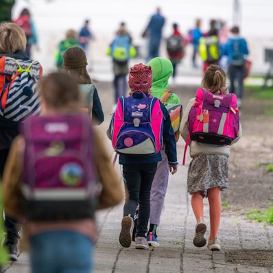 Schulkinder gehen in die Schule.
