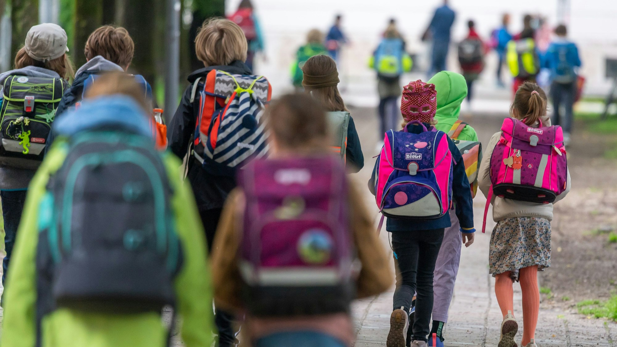 Schulkinder gehen in eine Schule.
