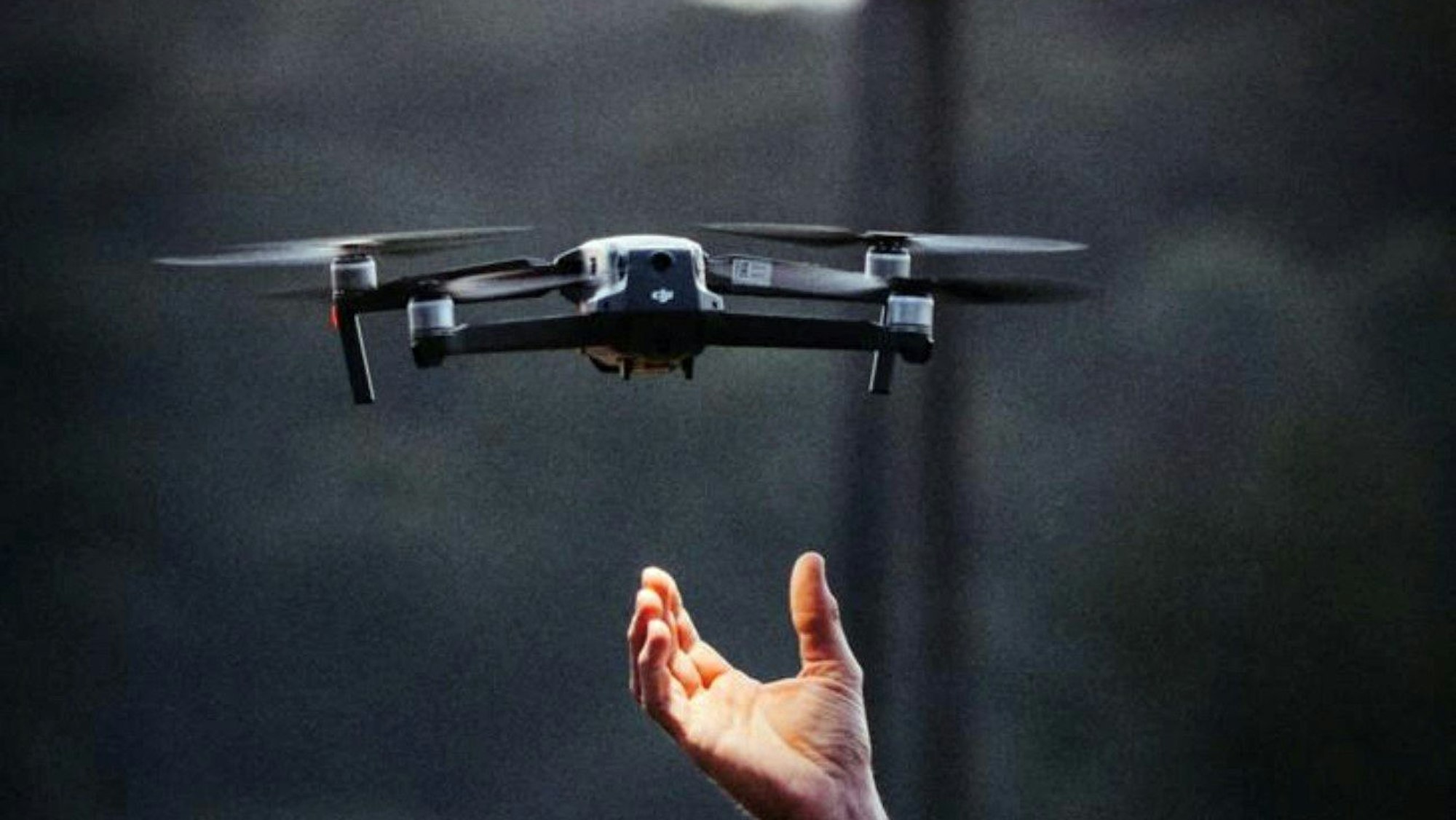 Eine Drohne schwebt über einer ausgestreckten Hand.