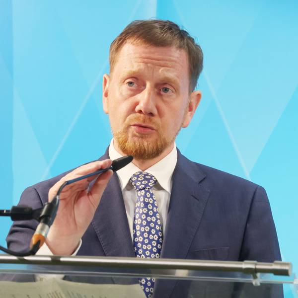 Der sächsische Ministerpräsident Michael Kretschmer (CDU) richtet bei einer Pressekonferenz sein Mikrofon.
