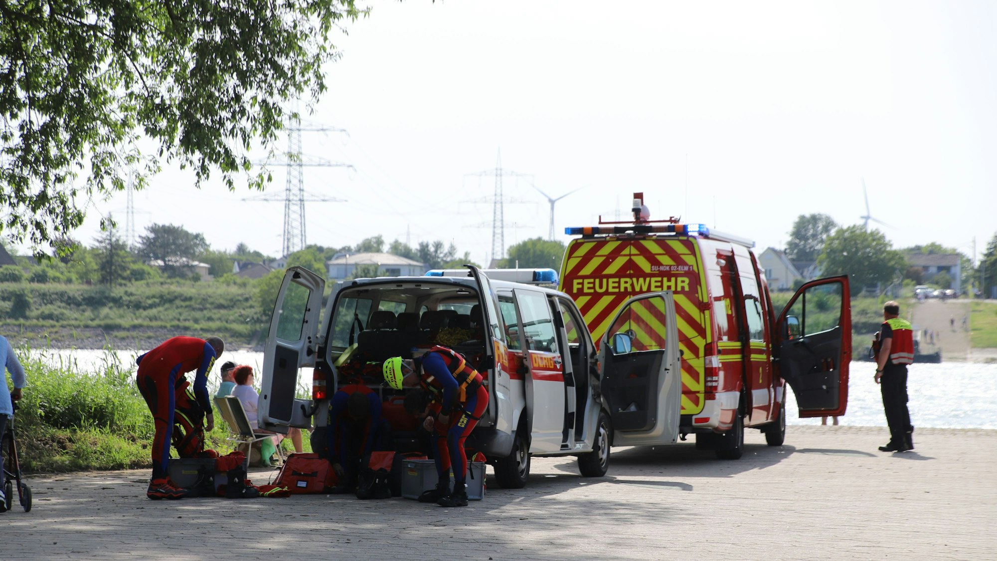 Rettungskräfte ziehen sich bei einem Einsatz an ihren Fahrzeugen um.