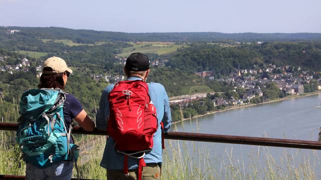 Zwei Wanderer schauen von einer Anhöhe auf den Rhein
