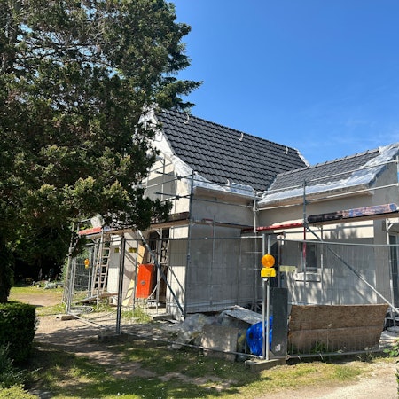 Ein Baugerüst steht um eine Halle.