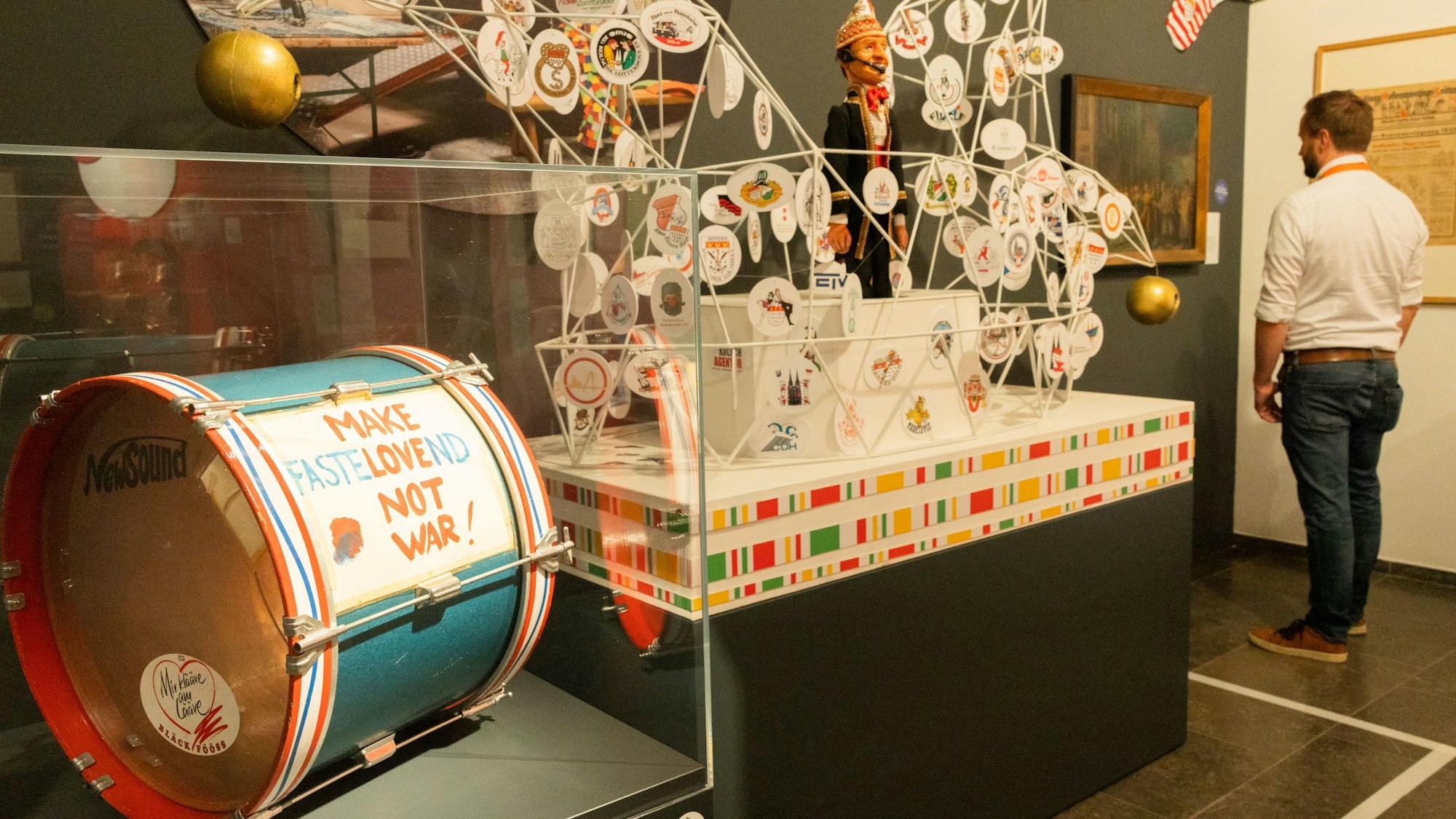 Eine dicke Trommel liegt in einem Glaskasten und weitere Ausstellungsstücke sind in einem Raum zu sehen.