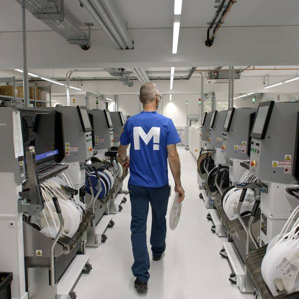 Es sind mehrere Computer zu sehen. Ein Mann geht durch den Gang.