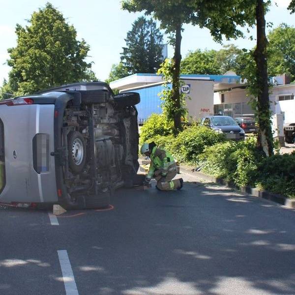 Auf der Straße liegt ein umgekippter Wagen. Feuerwehrleute kümmern sich um den Unfall.