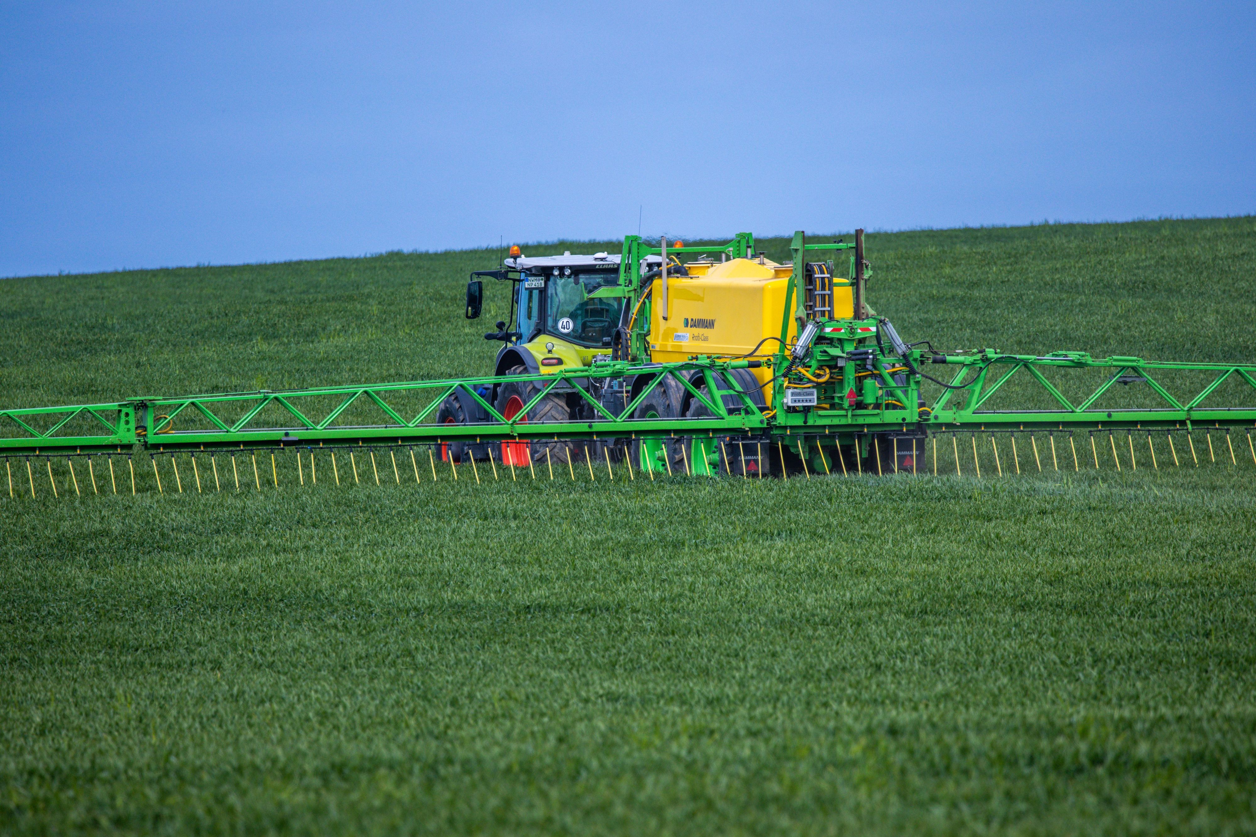 Ein Traktor verteilt Dünger auf einem Feld. In Dünger ist Nitrat enthalten, das bei zu intensivem Düngen gefährliche Rückstände im Grundwasser hinterlassen kann. Nun hat die EU-Kommission ein Verfahren um nitrathaltiges Wasser eingestellt. (Symbolbild)