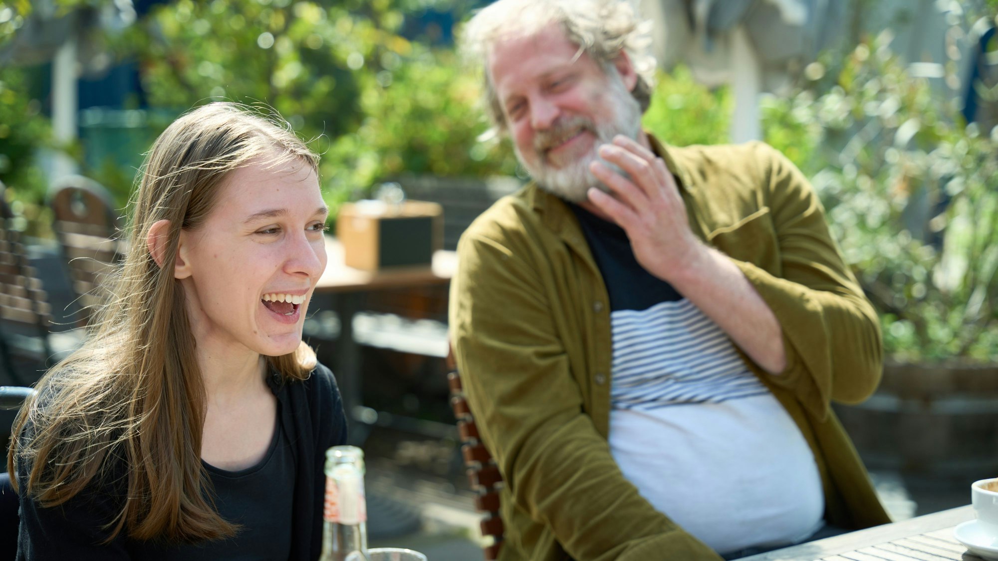 Lorelei Holtmann und Benjamin Höppner sitzen an einem Tisch und sind am Lachen.