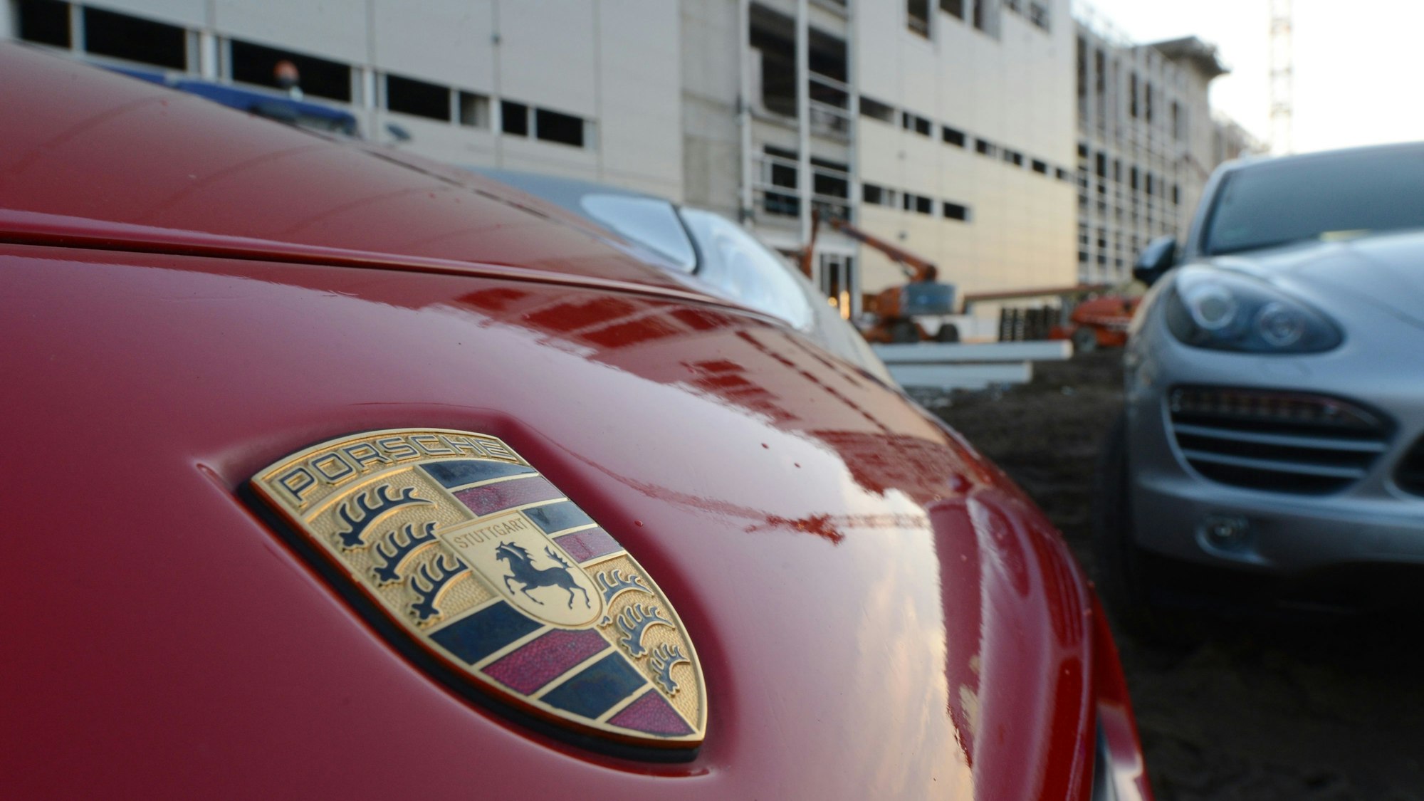 Ein Porsche steht auf einem Werksgelände in Leipzig (Sachsen). So sieht das Logo von Porsche heute nicht mehr aus. (Archivbild)