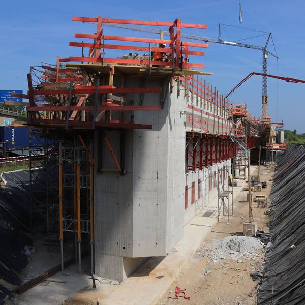 Eine Großbaustelle mit Betonblöcken und Kränen an der A59 bei Bonn.