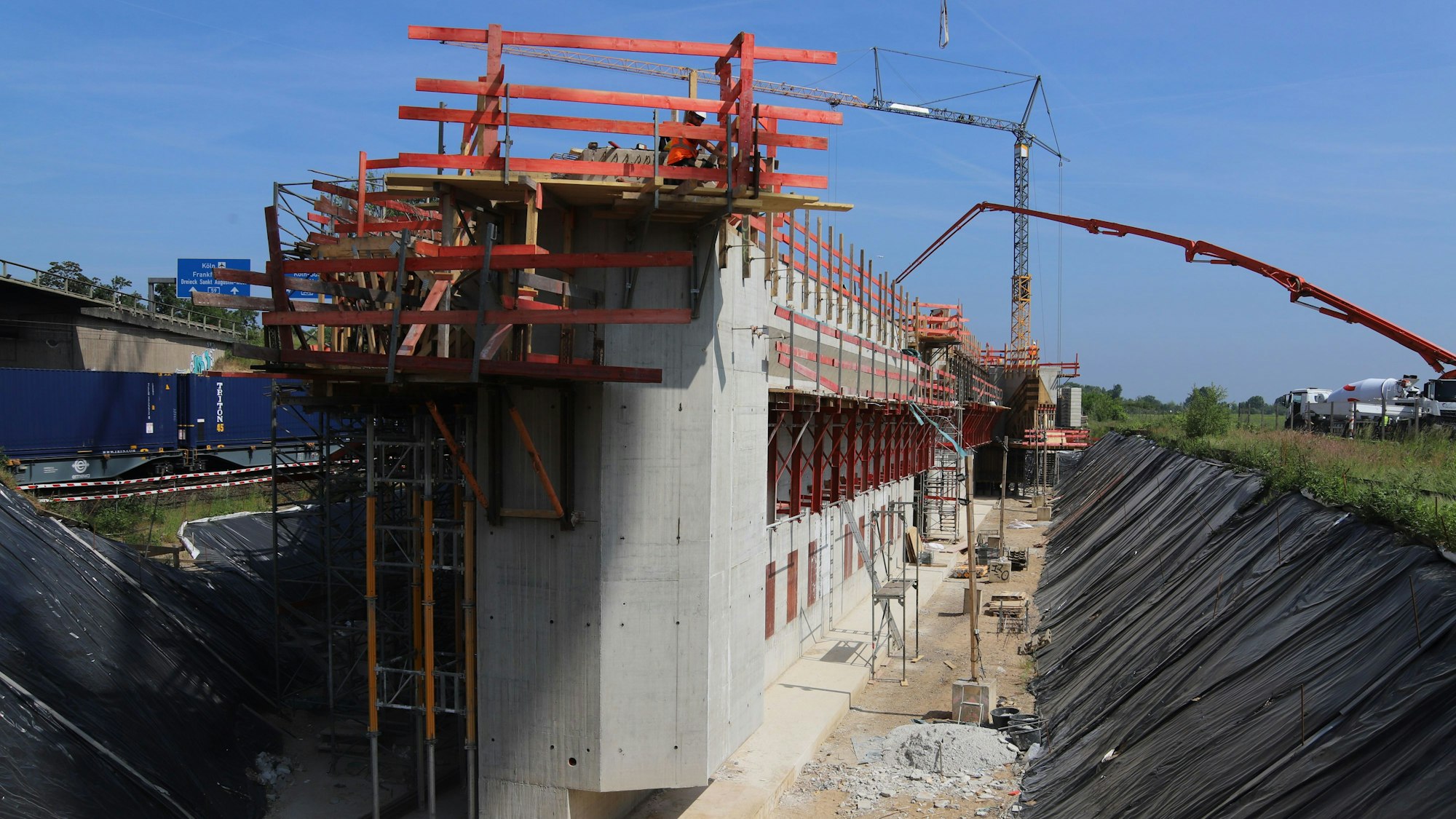 Eine Großbaustelle mit Betonblöcken und Kränen an der A59 bei Bonn.