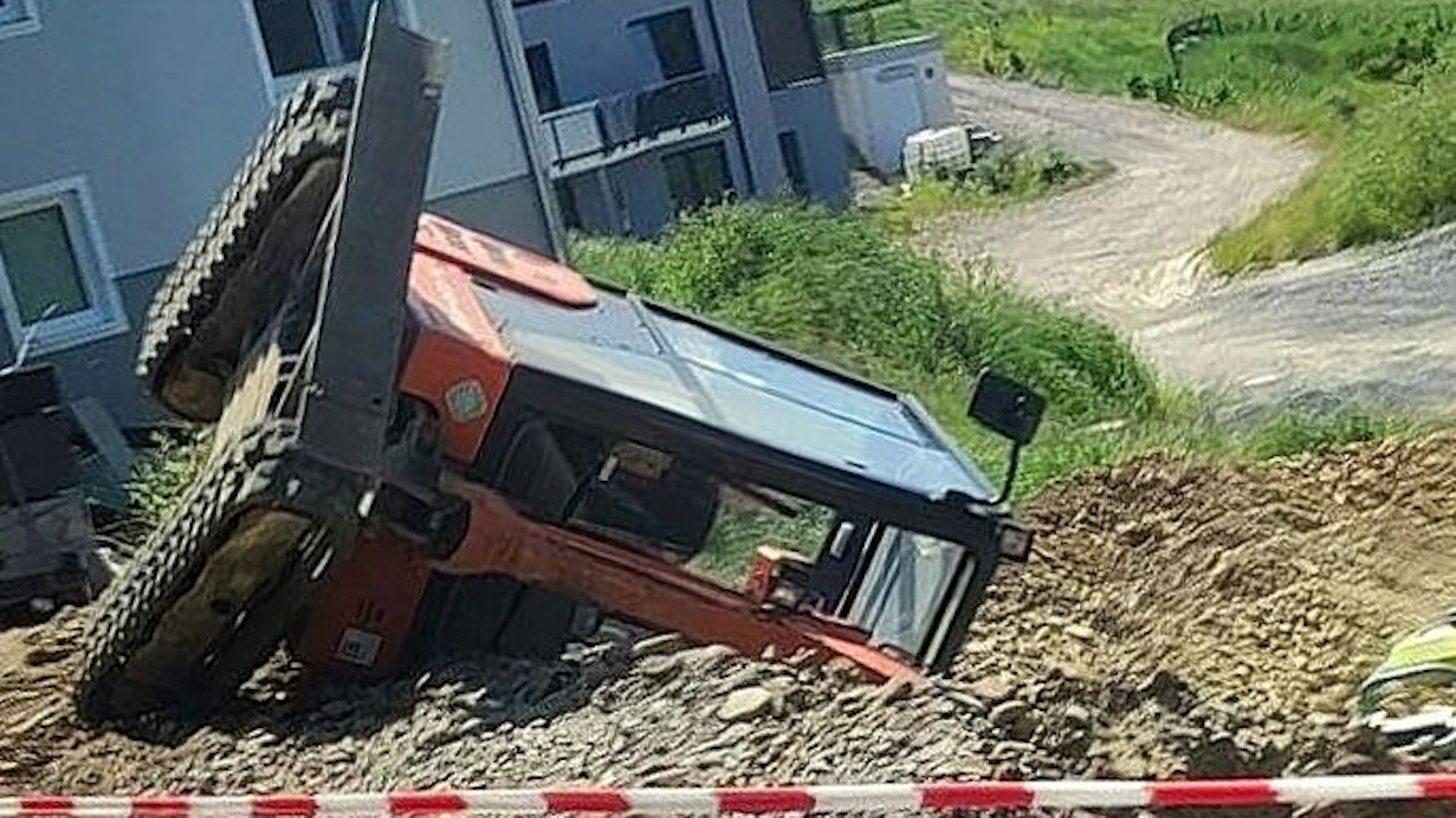 Ein Bagger liegt an einem Abhang auf der Seite, im Vordergrund ist Absperrband gespannt.