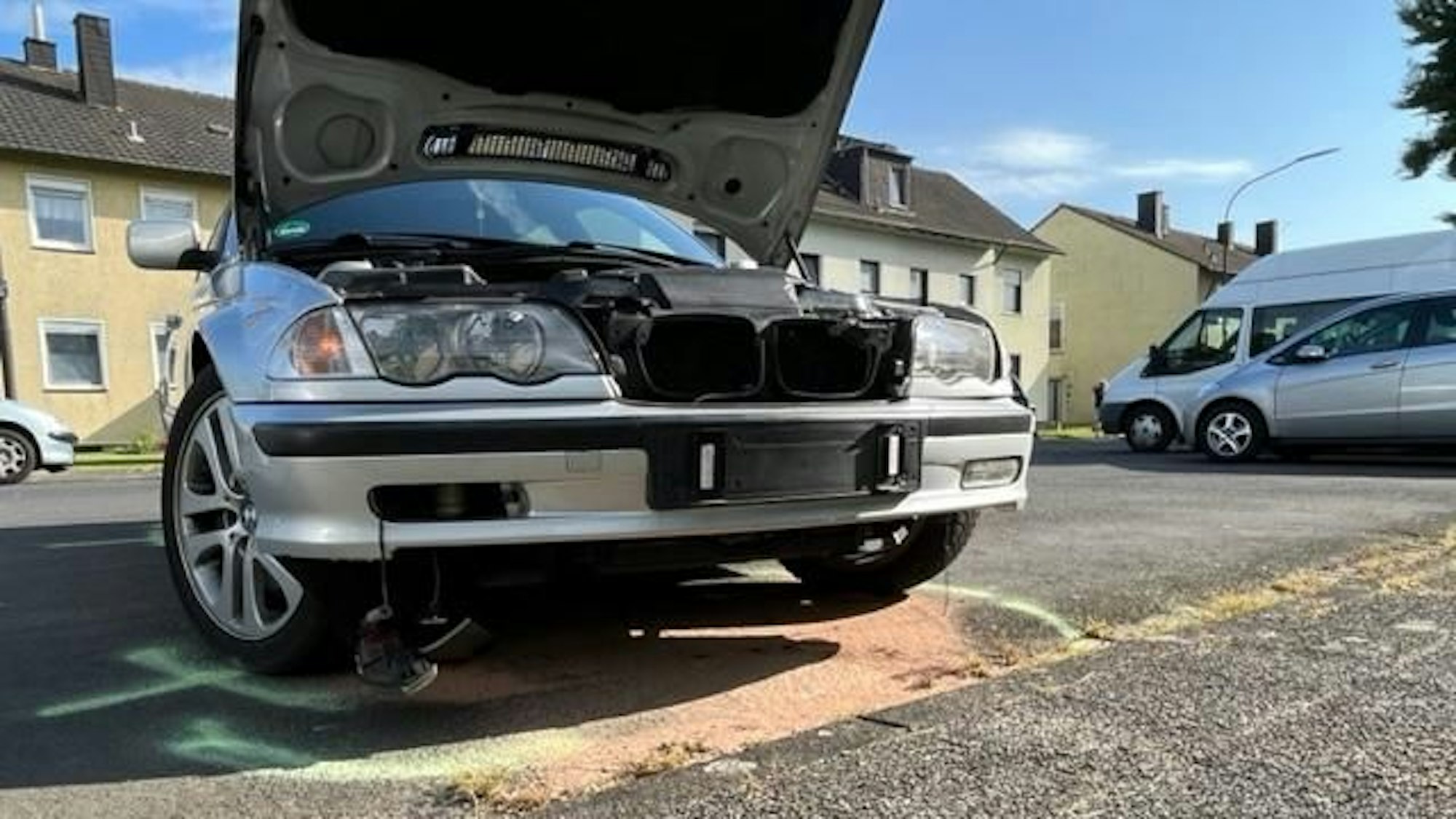 Ein beschädigtes Auto steht auf einer Straße.