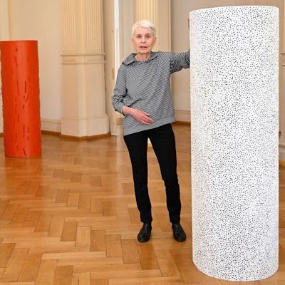 Mechtild Frisch steht neben einer ihrer Skulpturen.