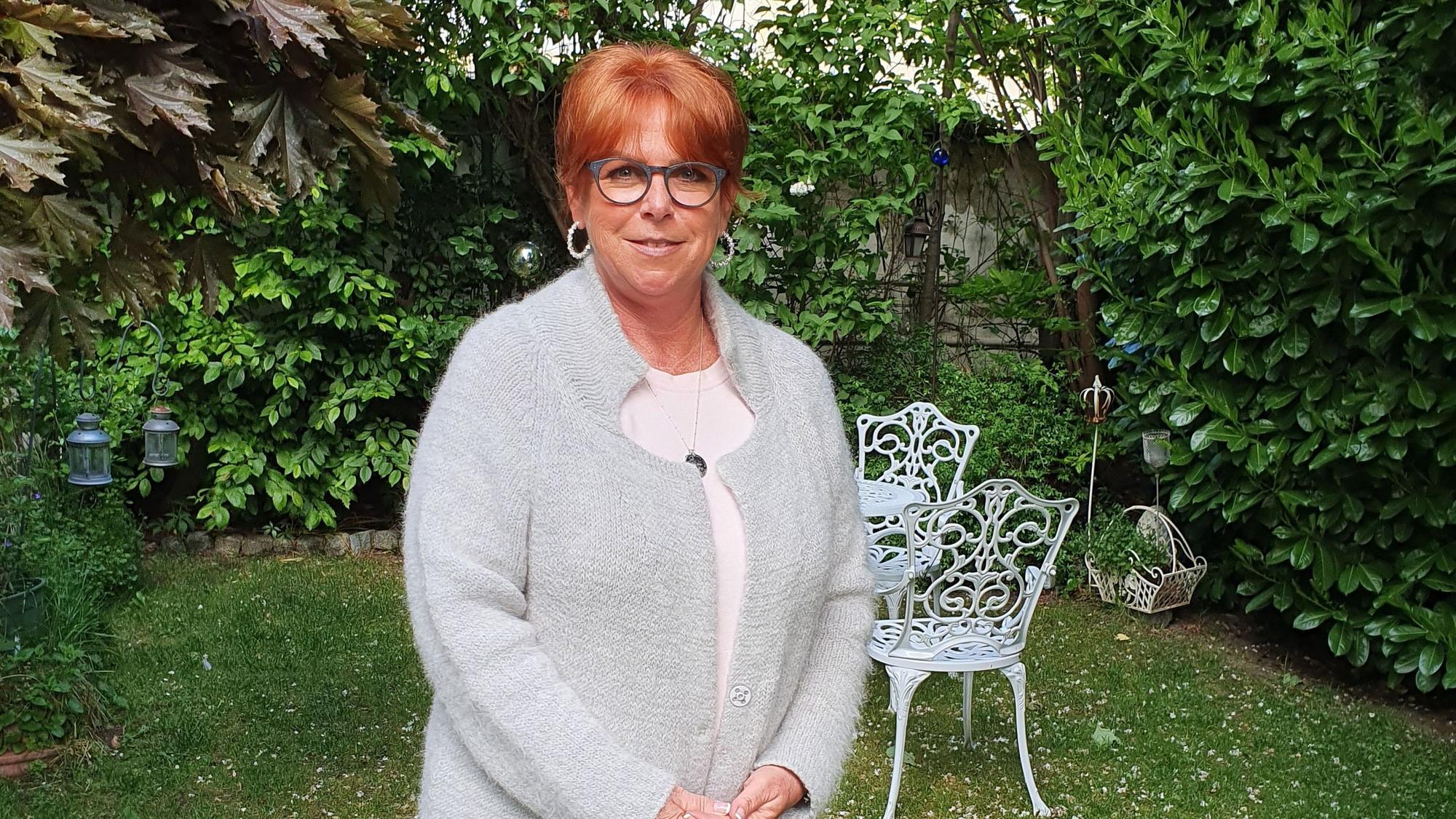 Eine Frau steht in ihrem Garten.