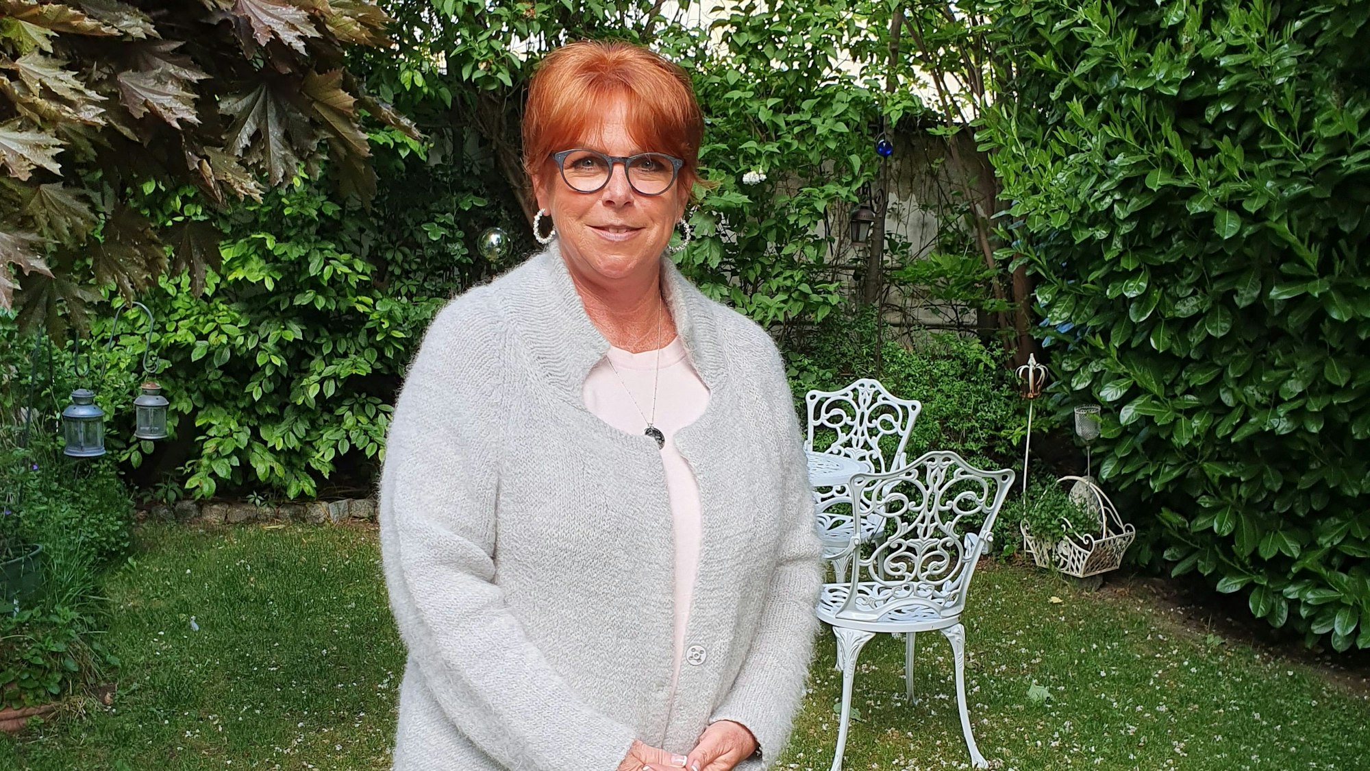 Eine Frau steht in ihrem Garten.