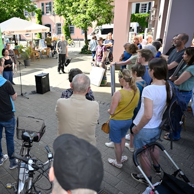 Menschen stehen um eine Sprecherin von Rösrath for Future herum.