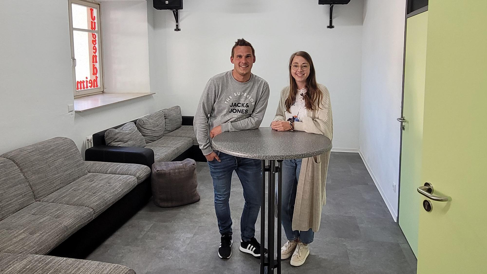 Ein Mann und eine Frau stehen an einem Stehtisch.