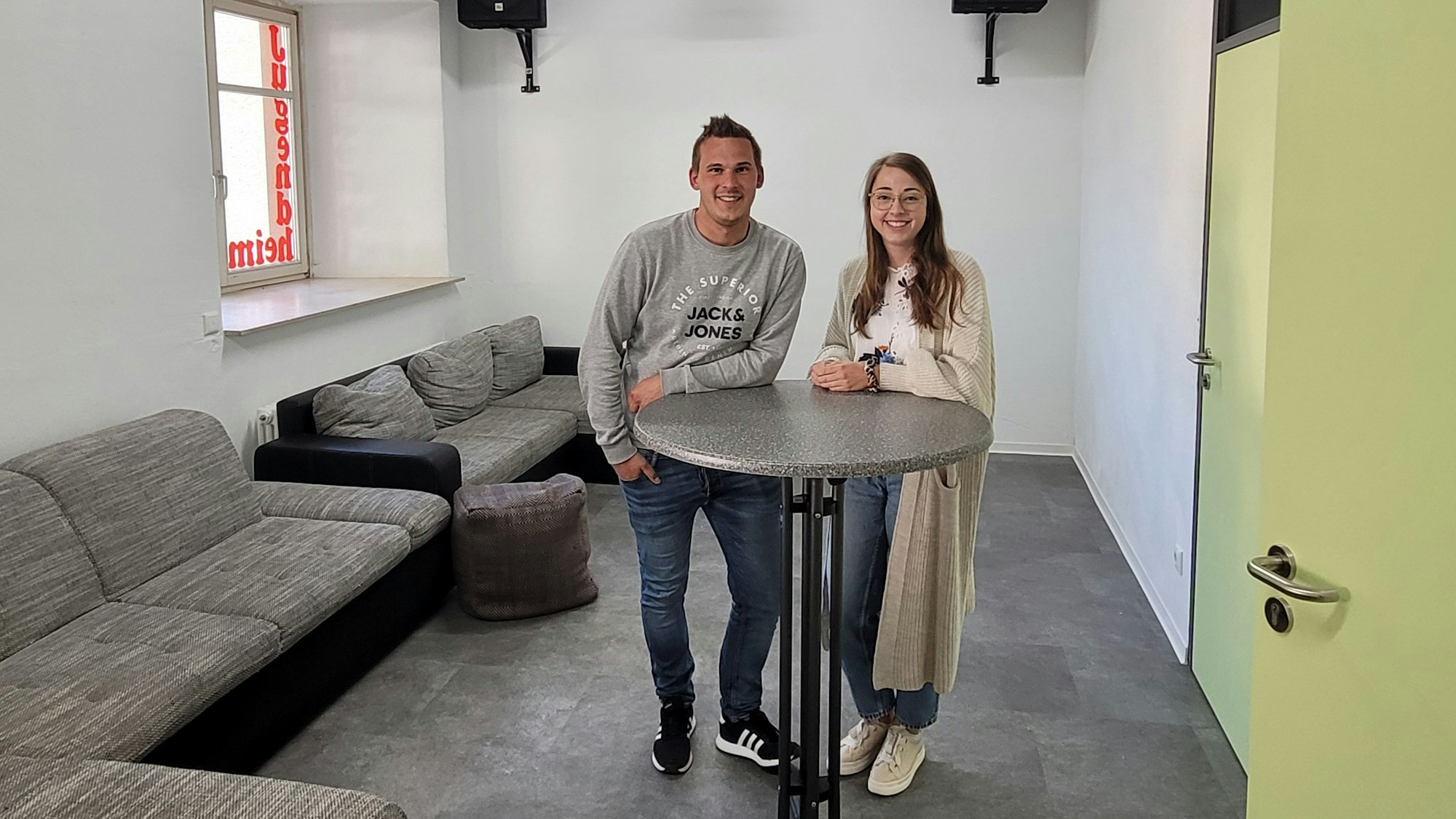 Ein Mann und eine Frau stehen an einem Stehtisch.