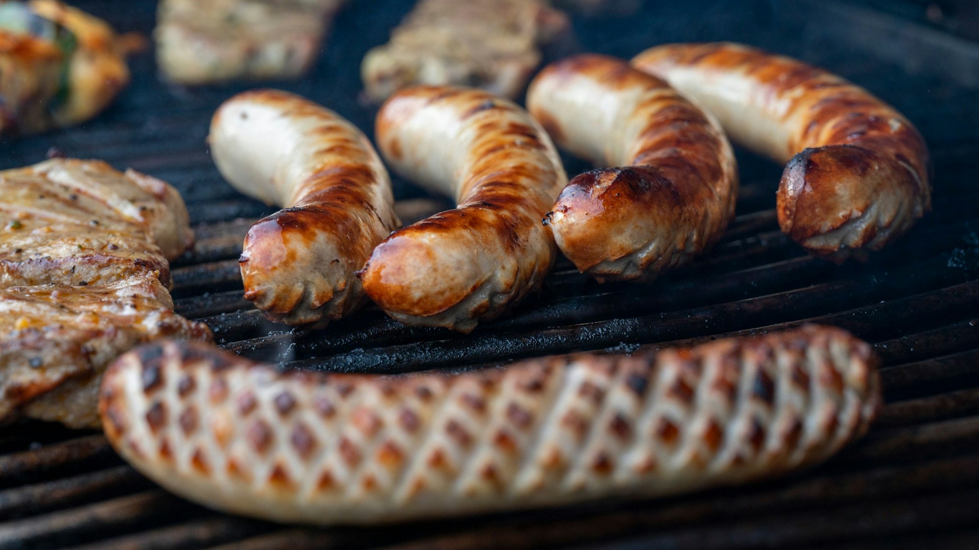 Würstchen liegen auf dem Grill.