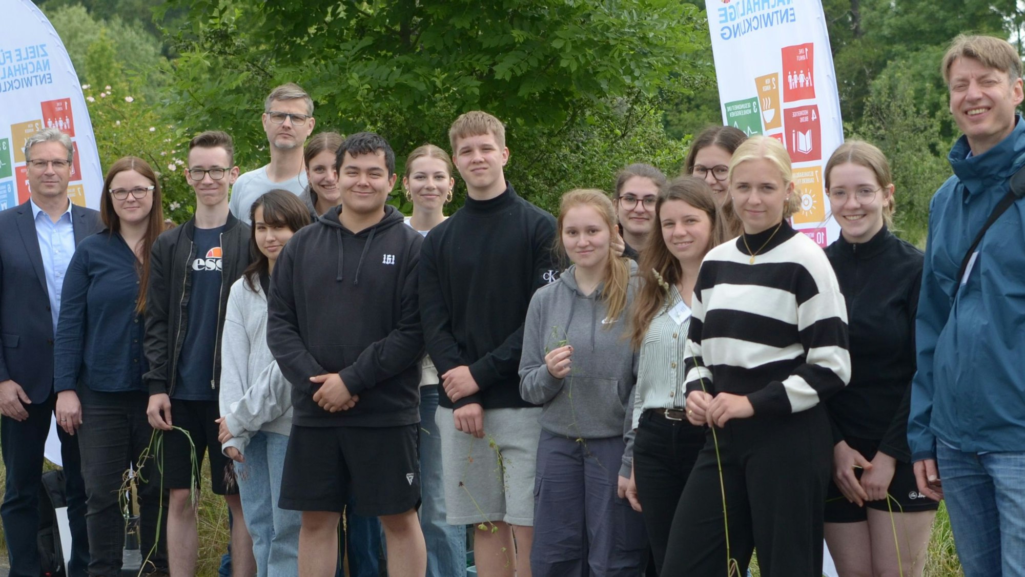 Das Bild zeigt eine Gruppe Schüler und Erwachsene, die an einem Projekt mitwirken.