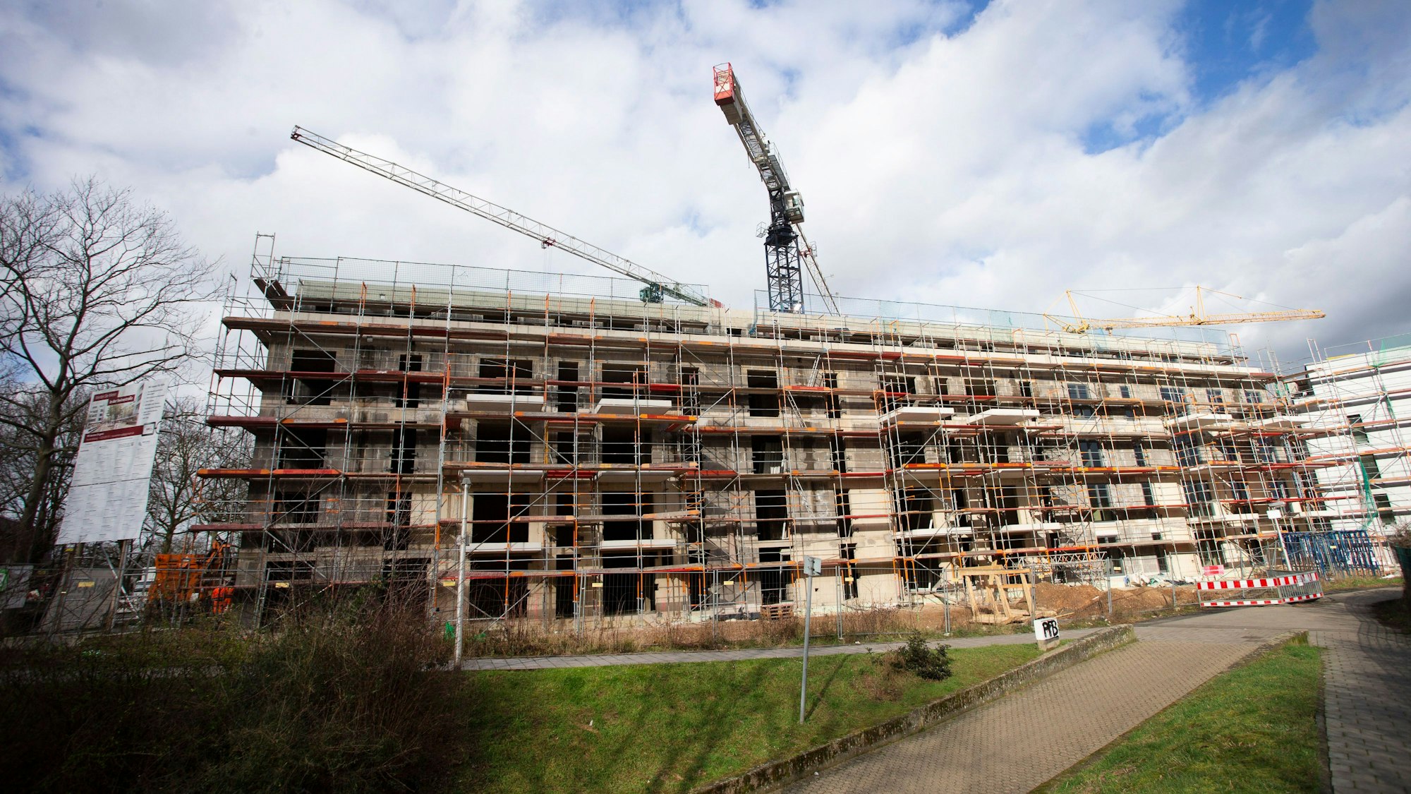 Ein Gebäudekomplex, der im Bau inbegriffen ist, ist mit einem Gerüst umstellt - im Hintergrund ragen Baukräne auf. (Symbolbild).