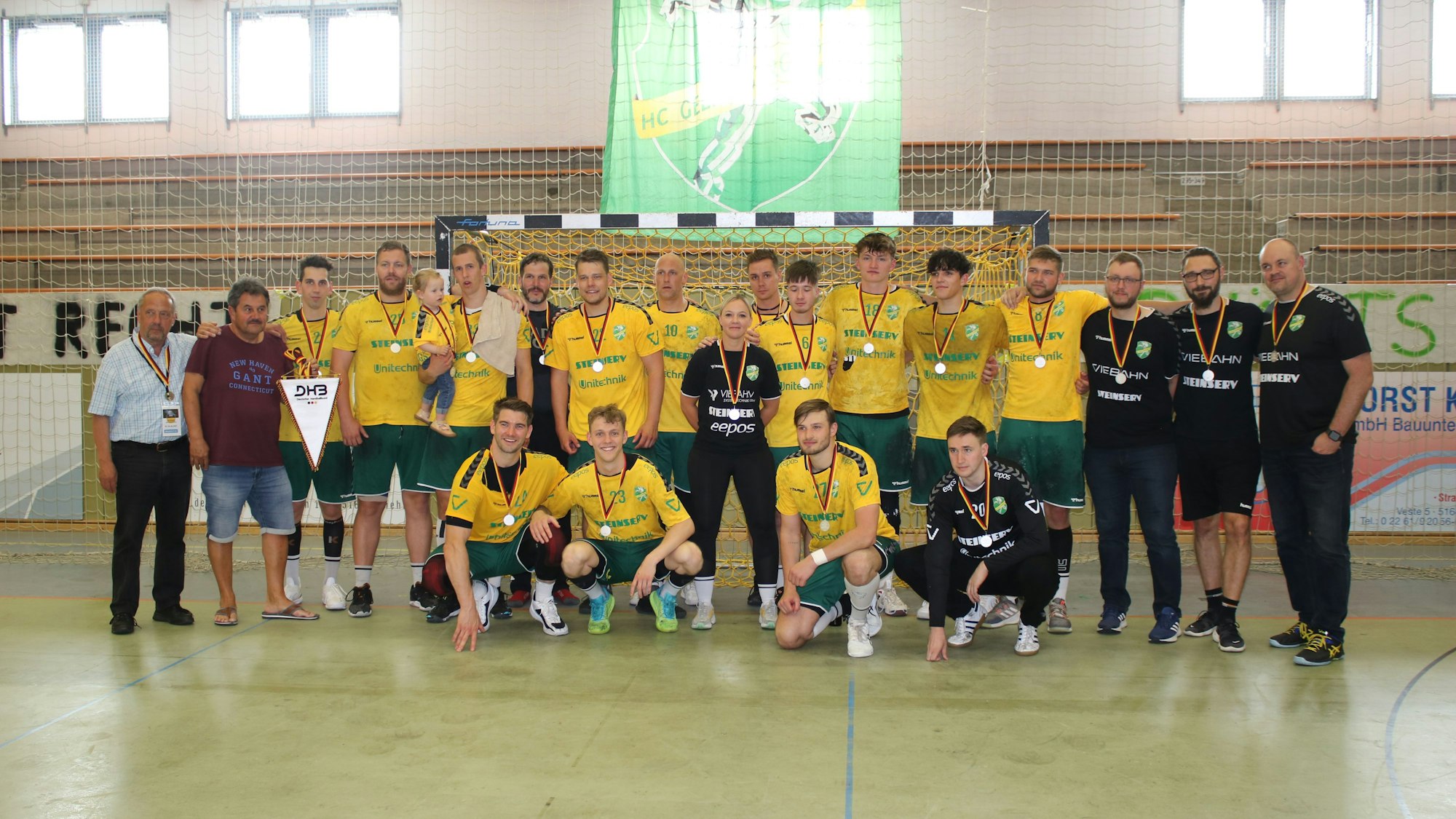 Ein Mannschaftsfoto des HC Gelpe/Strombach. Spieler und Trainer haben Medaillen um den Hals.