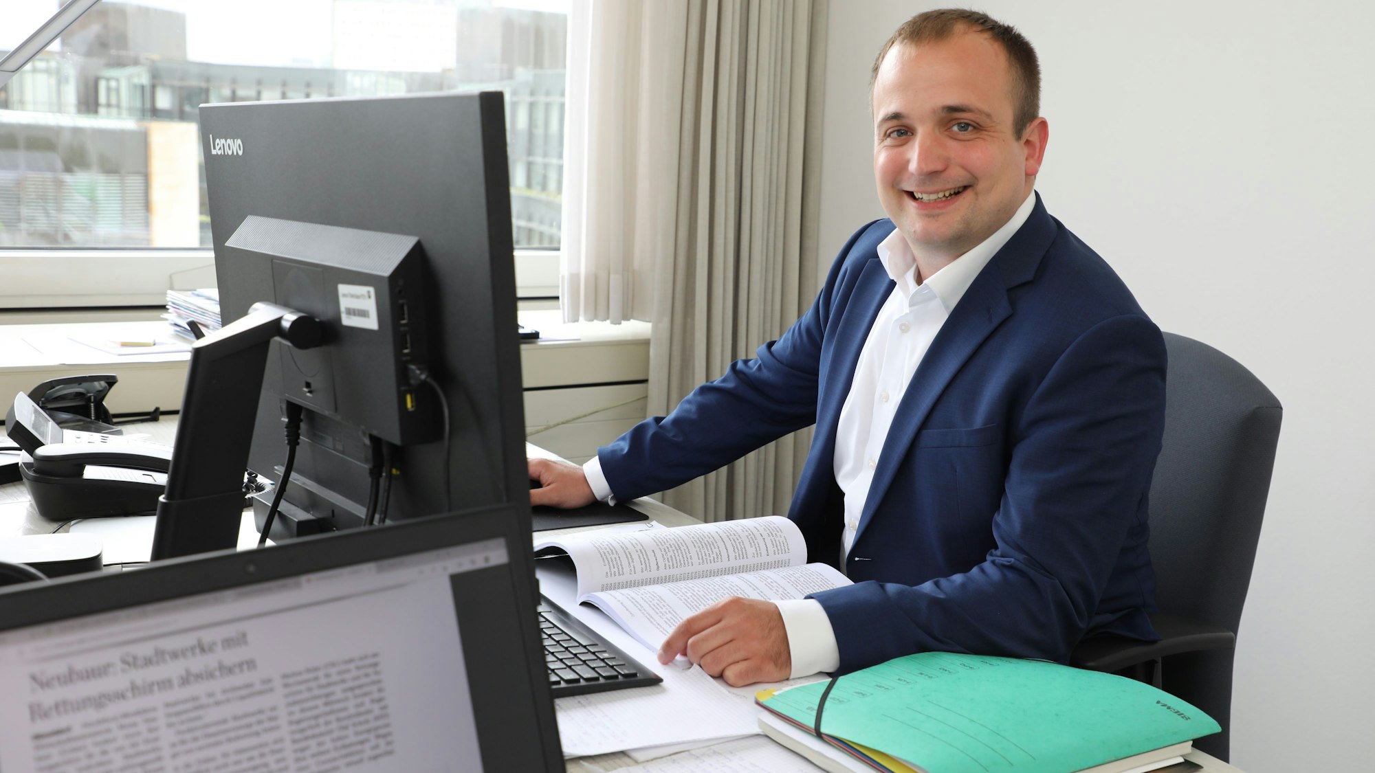Der Landtagsabgeordnete Martin Lucke sitzt am Schreibtisch seines Abgeordnetenbüros im Düsseldorfer Landtag. Durchs Fenster ist der Innenhof des Landtagsgebäudes zu sehen.