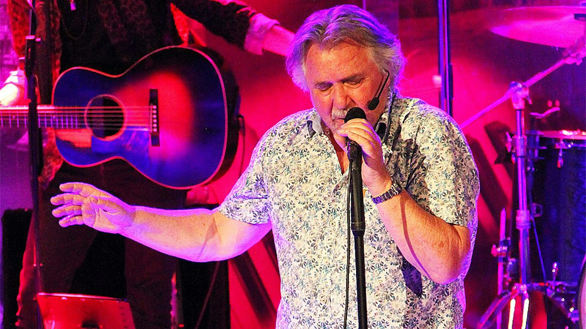 Auf der Bühne steht der Musiker Tommy Engel und singt ins Mikrofon.