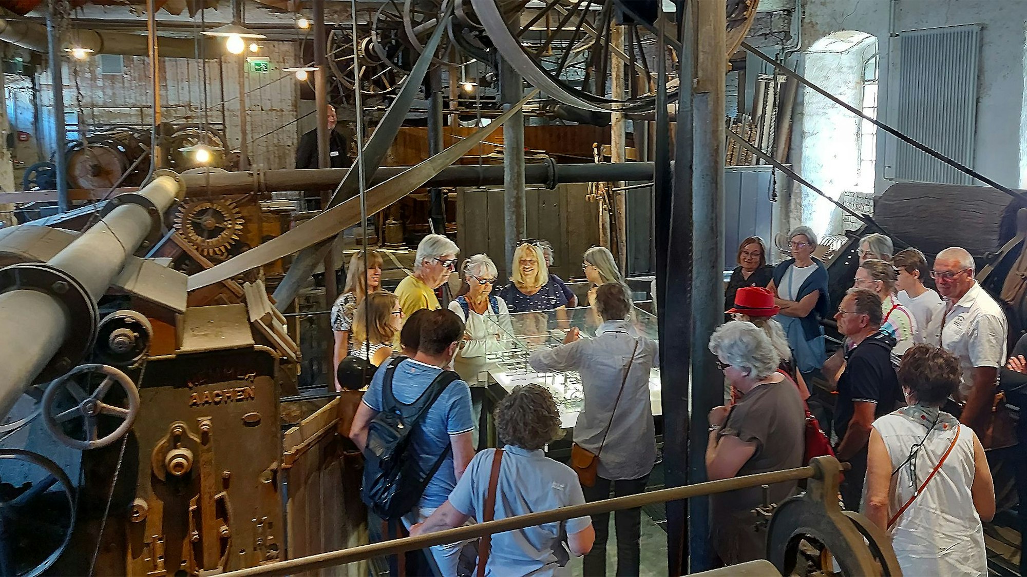 Eine Menschengruppe steht im Rahmen einer Führung in der historischen Tuchfabrik in Kuchenheim.