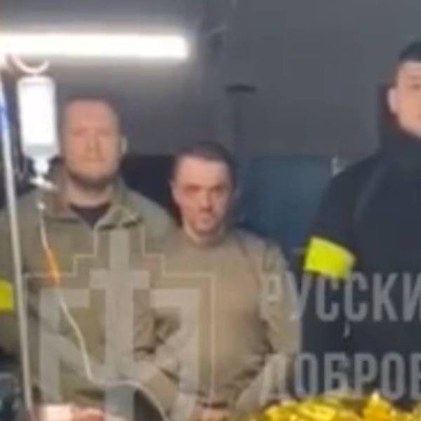 Kämpfer des „Russischen Freiwilligenkorps“ posieren in einem Video mit einem mutmaßlichen russischen Kriegsgefangenen. Der Anführer der Gruppe, schwarz gekleidet, ist der Neonazi Denis Kapustin, der mehrere Jahre in Köln gelebt hat.