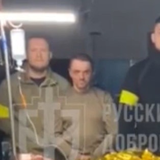 Kämpfer des „Russischen Freiwilligenkorps“ posieren in einem Video mit einem mutmaßlichen russischen Kriegsgefangenen. Der Anführer der Gruppe, schwarz gekleidet, ist der Neonazi Denis Kapustin, der mehrere Jahre in Köln gelebt hat.