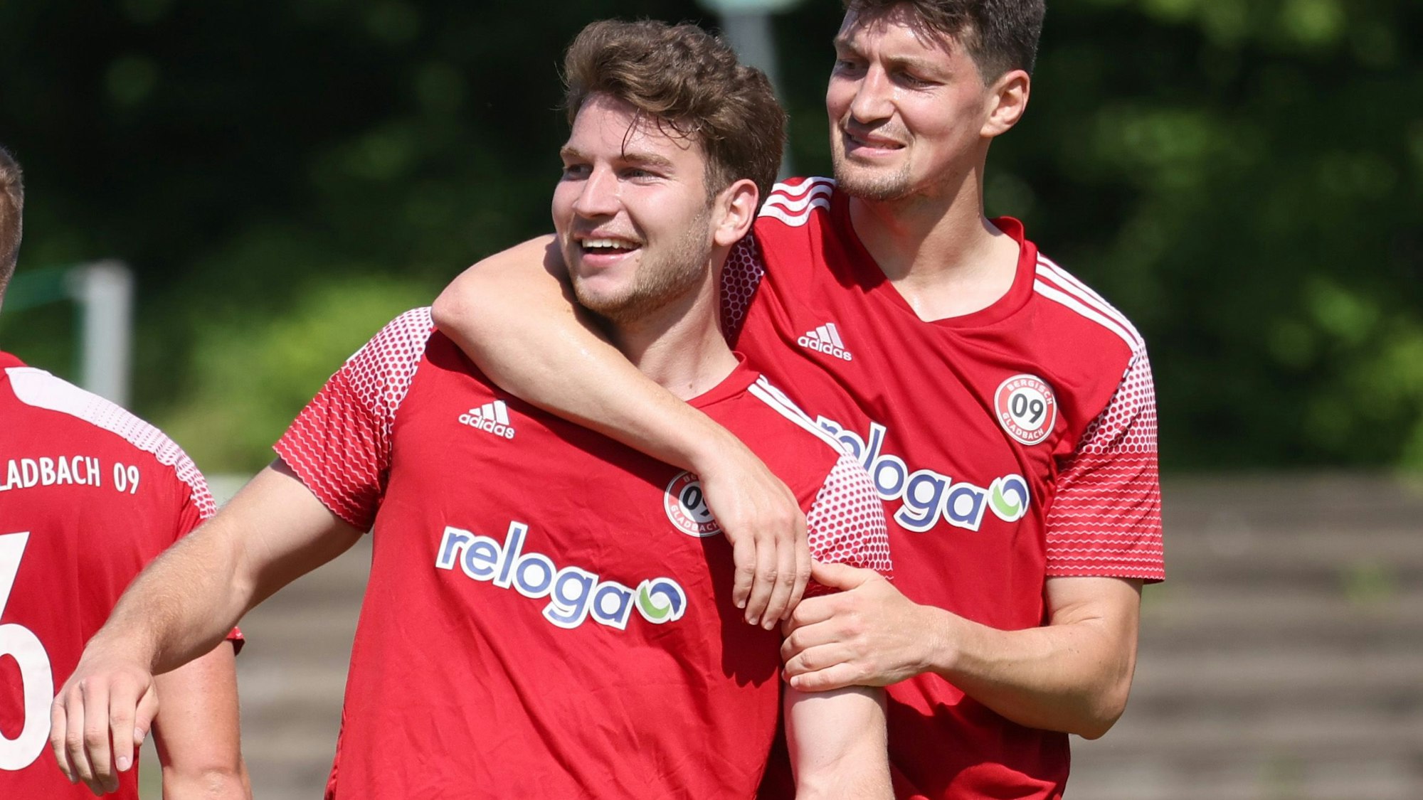 Ein Fußballer legt seinen Arm um einen Teamkollegen.