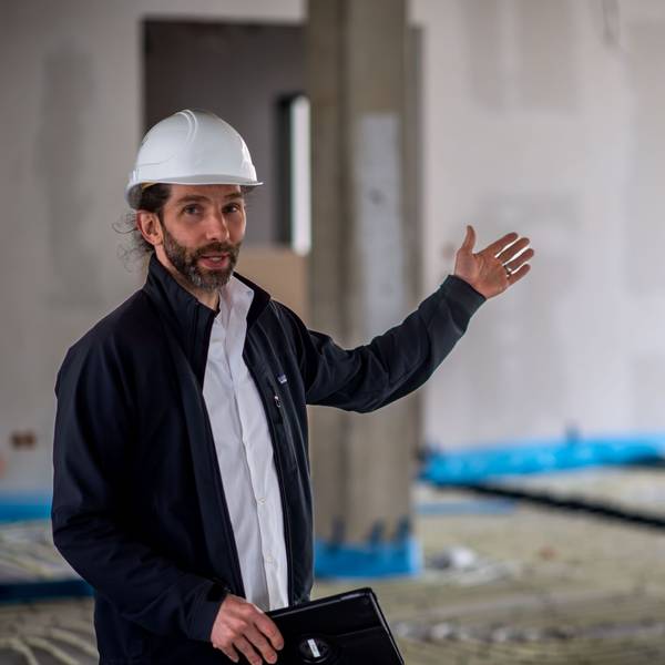 Thilo Lenhard steht in der Baustelle des Kreishauses und deutet in den leeren Raum.